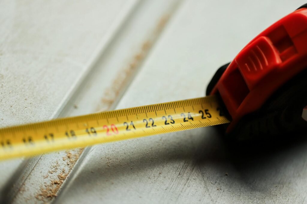 A desk with paint swatches, receipts, a calculator, and a measuring tape for a room update